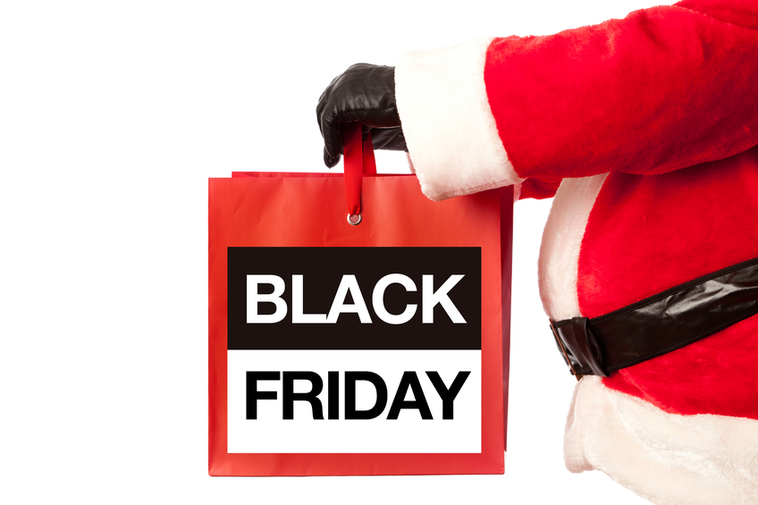 Christmas Santa Claus with a Black Friday Shopping billboard sign presented on a white background. A happy Santa Claus pointing at a Black Friday sign, the biggest Christmas shopping day on the Friday after Thanksgiving. Photographed in vertical format, Isolated on a white background.